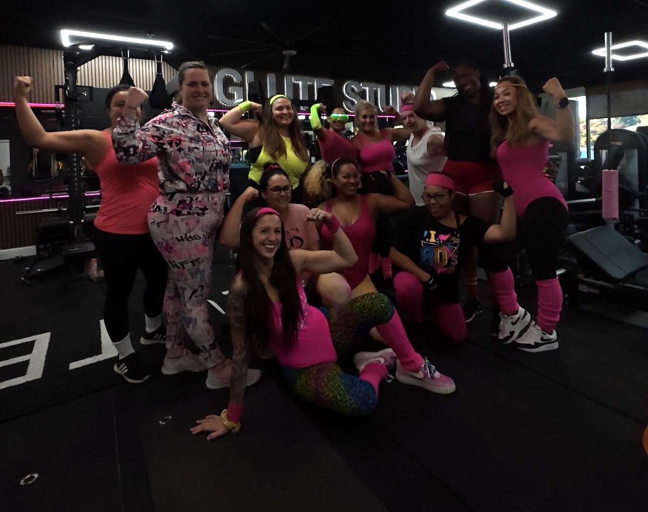 Glute Studio members flexing in neon 80s workout gear