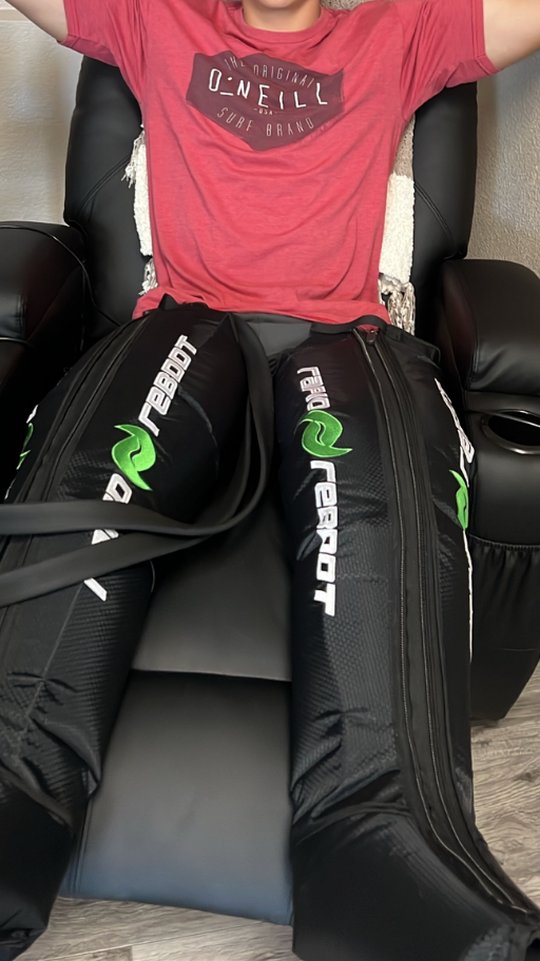 Client relaxing in compression therapy leg sleeves