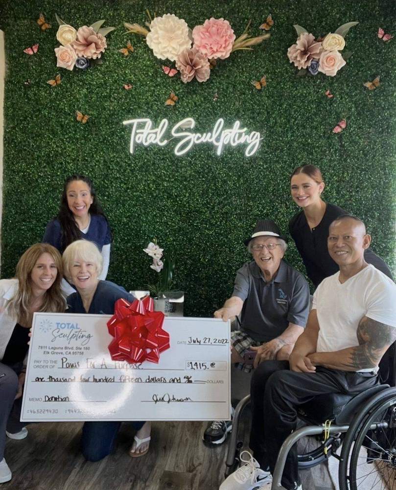 Team presenting a donation check to Paws For A Purpose