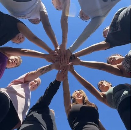 Members with hands in together, shot from below