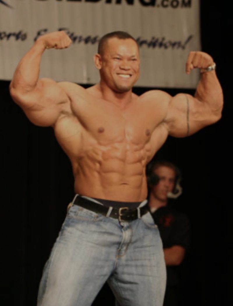 IFBB Pro Kris Dim flexing on stage
