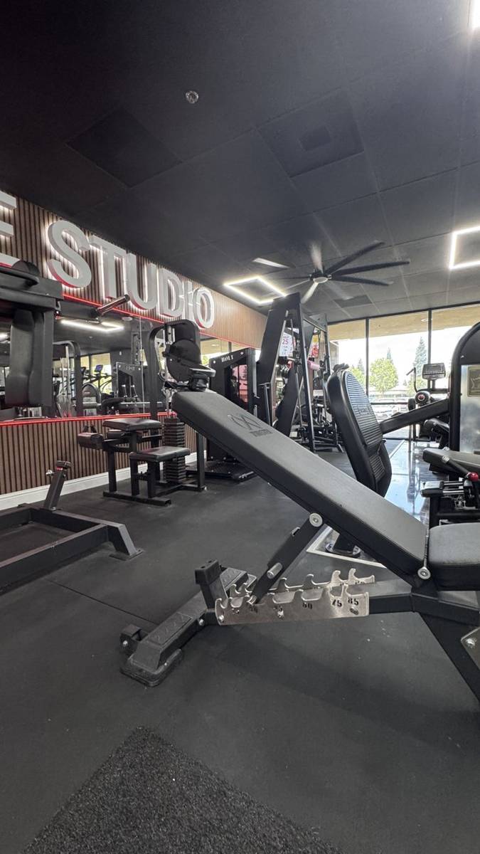 Adjustable bench in front of the lit GLUTE STUDIO sign